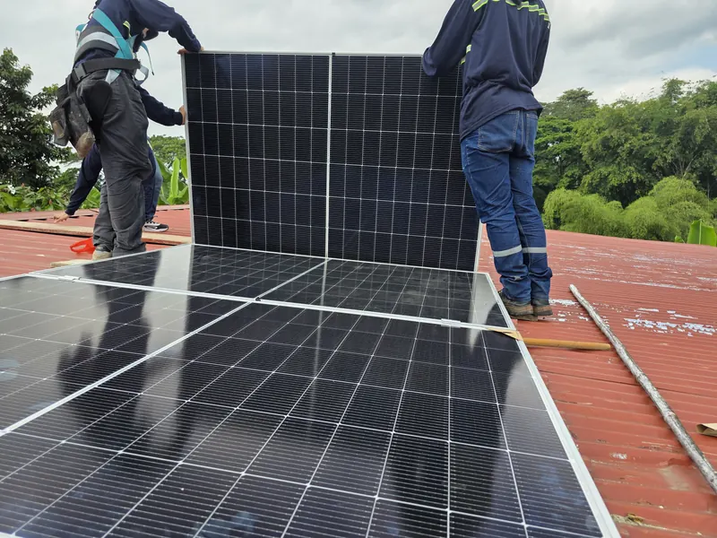 Equipo técnico colocando paneles solares sobre una cubierta