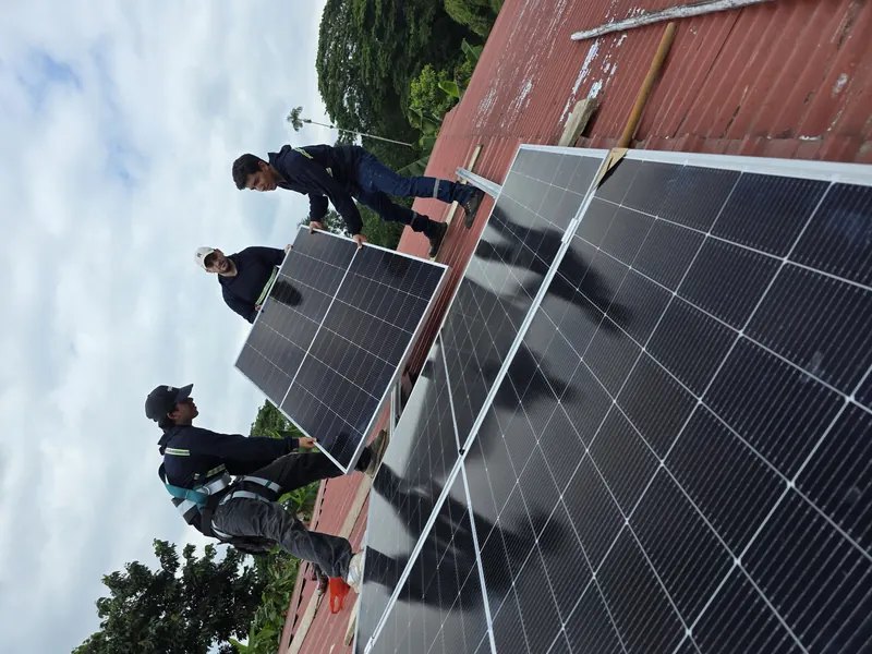 Equipo técnico instalando paneles solares en una propiedad rural